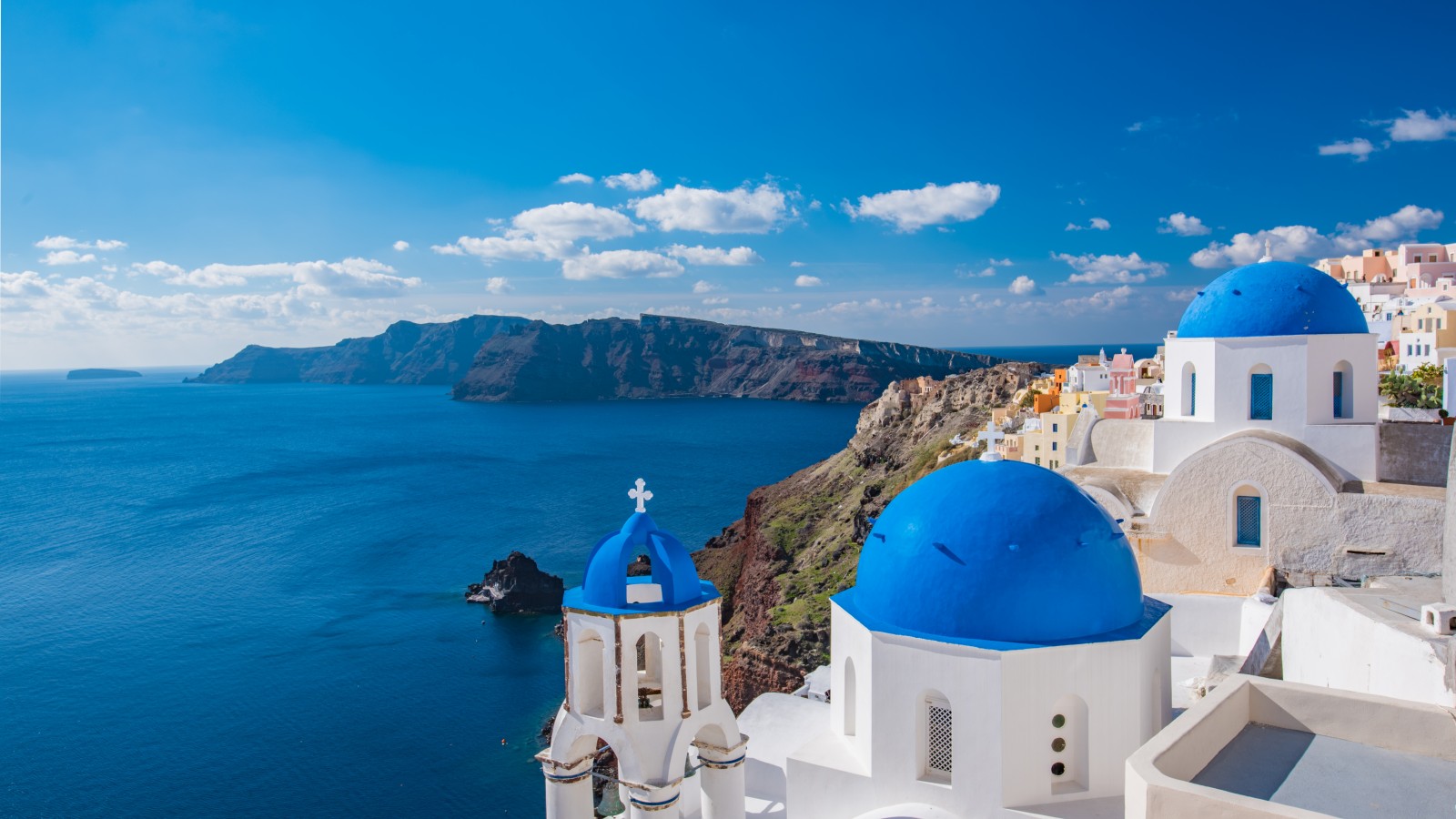 White washed, cubiform houses dot the Santorini's hilltops overlooking the Aegean Sea